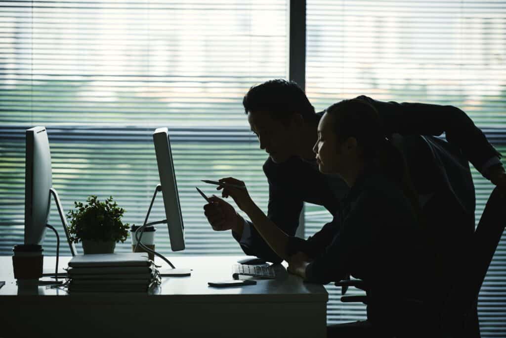 Two people looking at a computer monitor, pointing