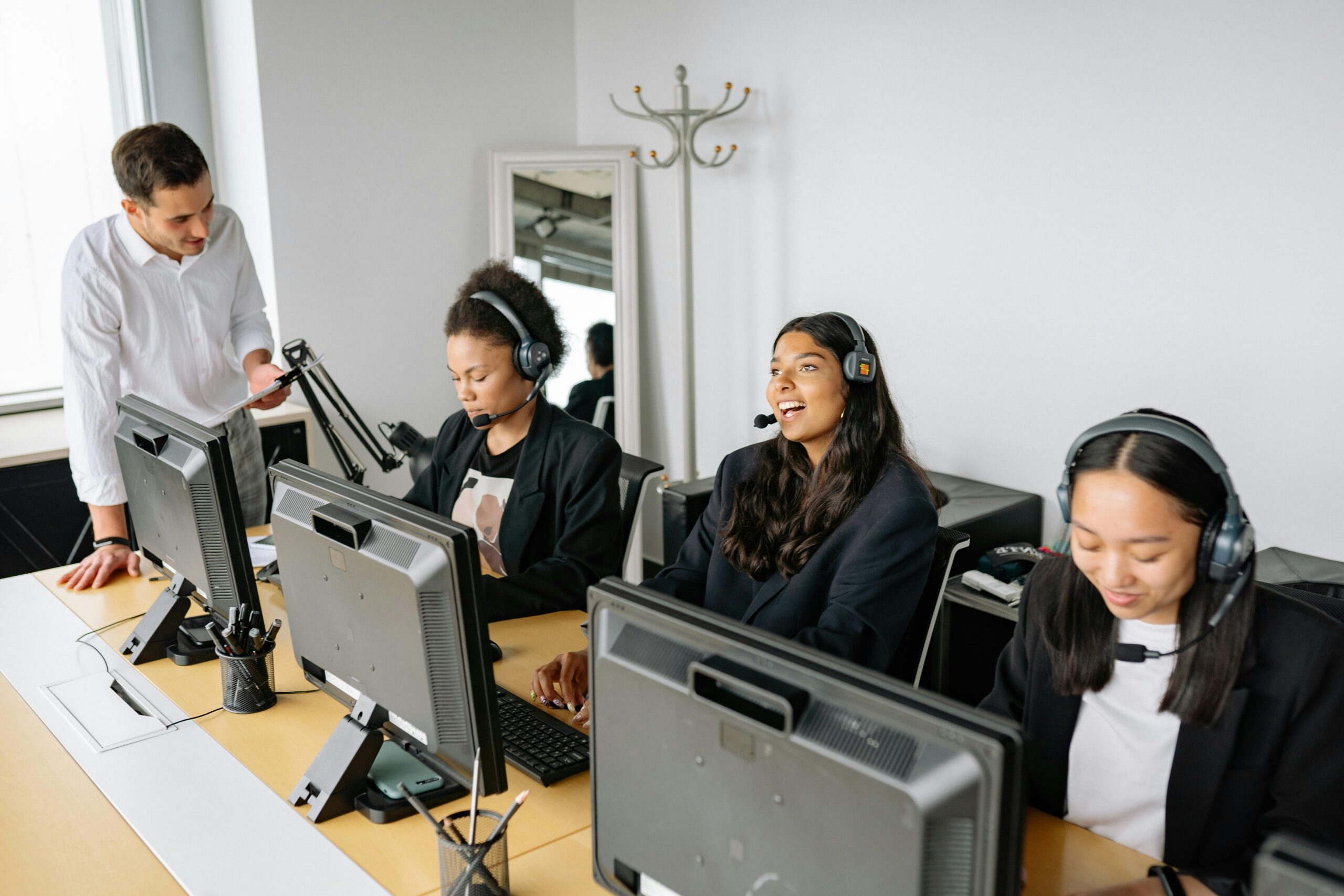 IT support team wearing headsets assisting clients at computer workstations IT support team wearing headsets assisting clients at computer workstations